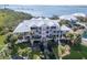 Stunning waterfront home with a white metal roof, lush landscaping, and multiple balconies overlooking the water at 11000 Placida Rd # 301, Placida, FL 33946
