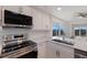 Beautiful kitchen featuring stainless steel appliances, white cabinets, and a scenic water view at 11000 Placida Rd # 301, Placida, FL 33946