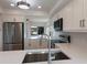 Modern kitchen features stainless steel appliances, white cabinets, and view to living room at 11000 Placida Rd # 301, Placida, FL 33946