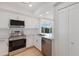 Updated kitchen with stainless steel appliances, white cabinets, and quartz countertops; with hardwood floors at 11000 Placida Rd # 301, Placida, FL 33946