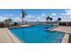 Large, sparkling community swimming pool with blue umbrellas overlooking a scenic waterfront at 11000 Placida Rd # 301, Placida, FL 33946