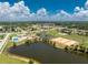 Wide aerial view featuring a lake, tennis courts, community pool and clubhouse in a well-maintained neighborhood at 13532 Romford Ave, Port Charlotte, FL 33981