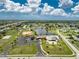 Expansive aerial view of the community featuring a lake, clubhouse, pool, and tennis courts at 13532 Romford Ave, Port Charlotte, FL 33981