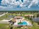 Aerial image showcasing community pool, clubhouse, and recreation areas under a bright, cloudy sky at 13532 Romford Ave, Port Charlotte, FL 33981