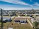 Aerial view of a fenced-in backyard with patio set, surrounded by neighborhood homes under a blue sky at 13532 Romford Ave, Port Charlotte, FL 33981