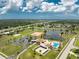Extensive aerial view of the property highlighting community features like a pool, lake, and tennis courts at 13532 Romford Ave, Port Charlotte, FL 33981