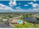 An aerial shot showcasing the community pool, clubhouse, lake, landscaping, and ample parking at 13532 Romford Ave, Port Charlotte, FL 33981