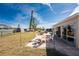 A view of the backyard of the home shows the patio with an outdoor table and fire pit at 13532 Romford Ave, Port Charlotte, FL 33981