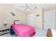 Cozy bedroom featuring a bright pink bedspread and colorful wall decorations at 13532 Romford Ave, Port Charlotte, FL 33981