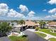 Beautifully landscaped clubhouse featuring a porte-cochere and serene lake views on a sunny day at 13532 Romford Ave, Port Charlotte, FL 33981