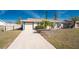 Charming exterior showcasing a well-maintained lawn, concrete driveway and attached garage at 13532 Romford Ave, Port Charlotte, FL 33981
