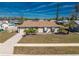 Charming home with manicured lawn, small palms, and a driveway leading to an attached garage at 13532 Romford Ave, Port Charlotte, FL 33981