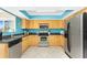 Bright kitchen features stainless steel appliances, wood cabinets, and blue accent wall at 13532 Romford Ave, Port Charlotte, FL 33981