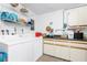 Functional laundry room features a washer, dryer, shelving, and counter space at 13532 Romford Ave, Port Charlotte, FL 33981