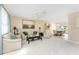 Spacious living room featuring neutral carpet, comfortable furnishings, and a ceiling fan at 13532 Romford Ave, Port Charlotte, FL 33981