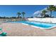 Inviting outdoor community pool surrounded by ample seating and lush palm trees at 13532 Romford Ave, Port Charlotte, FL 33981