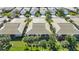 Aerial view of a community featuring villas, mature trees, and a serene lake nearby at 1577 Monarch Dr # 1577, Venice, FL 34293