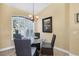 Charming dining area with a round glass table, four chairs, and a window with plantation shutters for natural light at 252 Australian Dr, Rotonda West, FL 33947