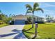 Attractive house with a well-kept lawn, mature landscaping, and a lengthy private driveway at 252 Australian Dr, Rotonda West, FL 33947