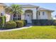 Inviting front entrance with lush landscaping, palm tree, and a charming covered entryway for a warm welcome at 252 Australian Dr, Rotonda West, FL 33947