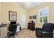 Well-lit office with a vaulted ceiling, wood flooring, and a comfortable chair. Includes a desk, filing cabinet, and artwork at 252 Australian Dr, Rotonda West, FL 33947
