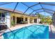 Inviting screened-in pool with outdoor seating and a grilling area, perfect for entertaining. Features a covered patio and landscaping at 252 Australian Dr, Rotonda West, FL 33947