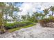 Scenic backyard with sandy ground, tropical foliage, and a tranquil waterfront view, perfect for relaxation and outdoor enjoyment at 331 Bocilla Dr, Placida, FL 33946