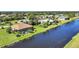 Aerial view of waterfront home with screened pool and beautiful landscaping on a sunny day at 39 Tournament Rd, Rotonda West, FL 33947