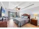 Main bedroom with trey ceiling, ceiling fan, hardwood floors and sliding glass doors with a view of the pool at 39 Tournament Rd, Rotonda West, FL 33947