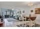 Bright living room featuring a ceiling fan, neutral walls, dining table, and sliding glass door to the patio at 5725 Greenwood Ave # 8101, North Port, FL 34287