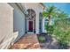 Home entrance with a screened-in porch and a red door at 8401 Gateway Ct, Englewood, FL 34224