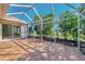 Spacious covered lanai with brick pavers and a view of the screened in enclosure at 8401 Gateway Ct, Englewood, FL 34224