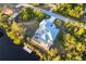 Aerial view of a home with screen lanai backing up to water, surrounded by lush greenery, and a private dock at 9519 Athel Dr, Port Charlotte, FL 33981