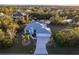 Aerial view of a landscaped property, with waterfront, a three-car garage, and a long driveway at 9519 Athel Dr, Port Charlotte, FL 33981