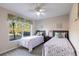 Bright bedroom with two beds, a ceiling fan, and a large window with tropical foliage at 9519 Athel Dr, Port Charlotte, FL 33981