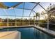 Screened in pool area with a swimming pool surrounded by lush greenery at 9519 Athel Dr, Port Charlotte, FL 33981