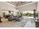 Open-concept living area boasts a coffered ceiling, wood flooring, and a seamless transition to the lanai at 9533 Arnaz Cir, Port Charlotte, FL 33981