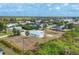 An aerial view of a light-blue, single-story home surrounded by lush greenery in a quiet neighborhood at 10307 Grail Ave, Englewood, FL 34224