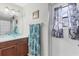 Bright bathroom featuring an updated vanity with a glass bowl sink, a window and a decorative mirror at 10307 Grail Ave, Englewood, FL 34224