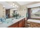 Modern bathroom with dual glass vessel sinks, a soaking tub, and decorative tile accents at 10307 Grail Ave, Englewood, FL 34224