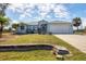 Inviting one-story home featuring a well-manicured lawn, lovely landscaping, and an attached two-car garage at 10307 Grail Ave, Englewood, FL 34224