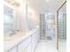 Bright, all-white bathroom featuring dual sinks, glass block accents, and ample lighting at 11000 Placida Rd # 101, Placida, FL 33946