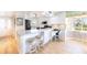 Modern kitchen with white cabinets, an island with bar seating, and stainless steel appliances for a sleek, bright space at 11000 Placida Rd # 101, Placida, FL 33946