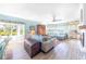 Inviting living room with calming paint, wood floors, water views, and an open concept to the dining area at 11000 Placida Rd # 101, Placida, FL 33946