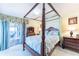 Main bedroom with a four-poster bed and access to a private balcony with water views, offering a serene escape at 11000 Placida Rd # 101, Placida, FL 33946