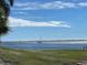 Sailboat on open water from grassy shoreline with scattered white wildflowers at 11000 Placida Rd # 101, Placida, FL 33946