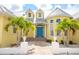 Inviting entrance with a blue front door, manicured landscaping, and a brick walkway at 1112 Andrews St, Englewood, FL 34224