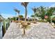 Beautifully landscaped dock and waterfront with lush green lawn and palm trees and canal views at 232 Bahia Vista Dr, Englewood, FL 34223