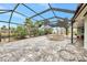 Enclosed pool area with grey brick floor, open pool and metal screening under a bright blue sky at 232 Bahia Vista Dr, Englewood, FL 34223