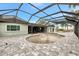 Enclosed pool area with grey brick floor, open pool and metal screening under a bright blue sky at 232 Bahia Vista Dr, Englewood, FL 34223